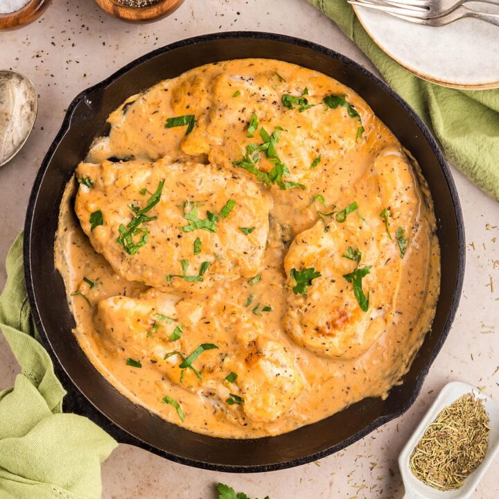 One-skillet smothered chicken with creamy Parmesan sauce ready to serve.