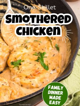 One-skillet smothered chicken cooking in skillet with rich creamy sauce.