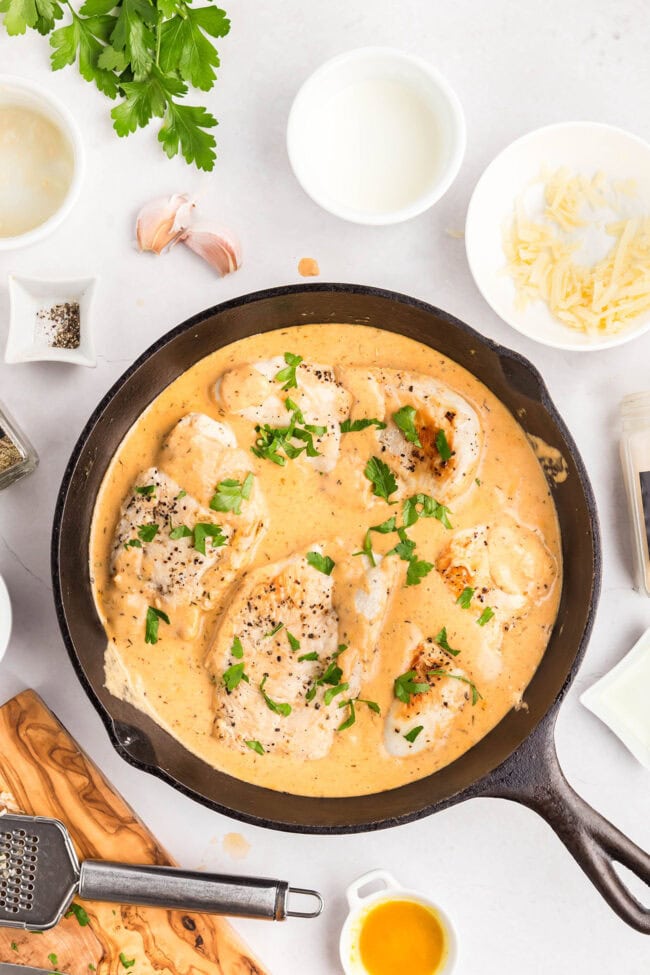 One-skillet smothered chicken with creamy Parmesan sauce ready to serve.