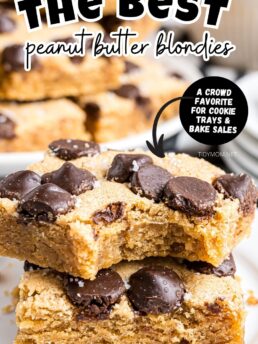 Stack of peanut butter blondies with a bite taken out of the top bar, showing their soft, chewy texture.