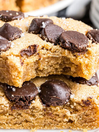 Horizontal shot of two stacked peanut butter blondies with a bite taken out of the top bar.