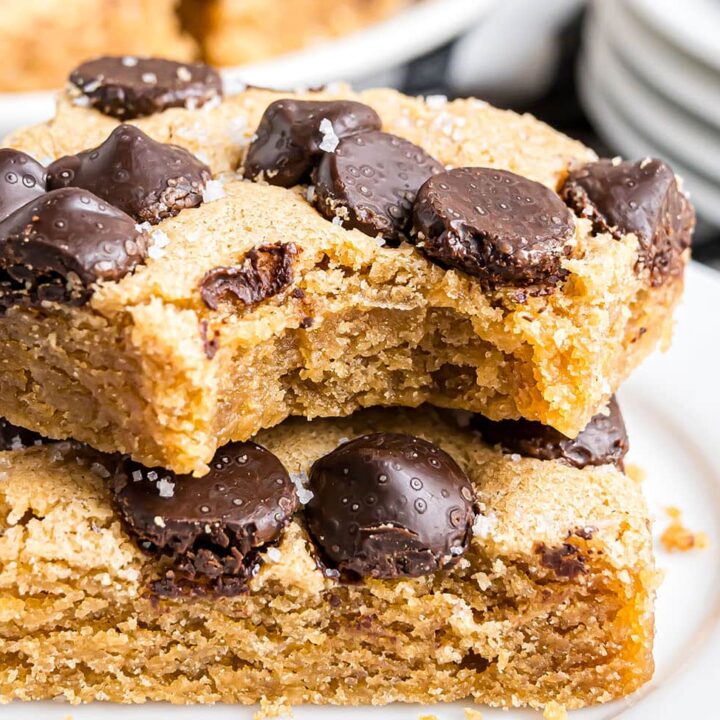 Horizontal shot of two stacked peanut butter blondies with a bite taken out of the top bar.