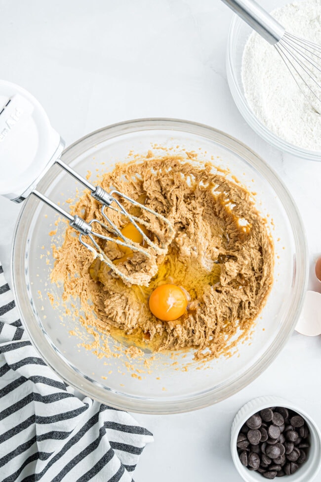 Creaming peanut butter, butter, and sugars with an electric mixer to make peanut butter blondie batter.