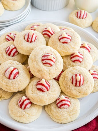 Side view of a plate stacked with Candy Cane Kiss Cookies, ready for serving.