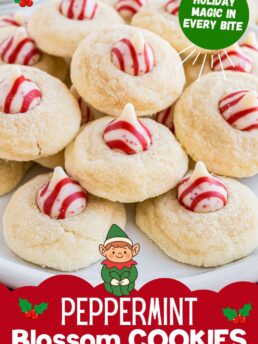 Pile of peppermint blossom cookies on a countertop with candy cane Hershey’s Kisses in the centers.