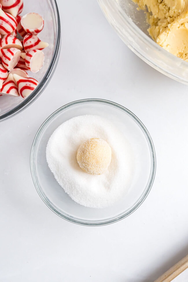 cookie dough ball in granulated sugar before baking.