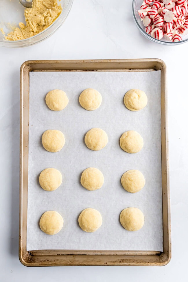 Freshly baked sugar cookies on a sheet pan before adding the Hershey’s Kisses.