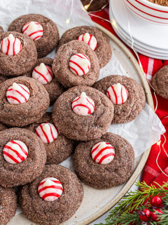 Overhead photo of Chocolate Peppermint Kiss Cookies spread out on parchment paper.