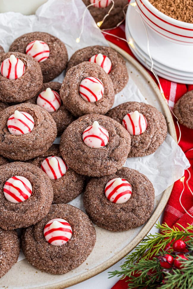 Overhead photo of Chocolate Peppermint Kiss Cookies spread out on parchment paper.