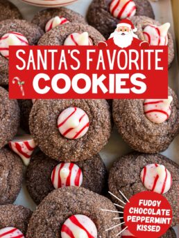 Overhead shot of Chocolate Peppermint Kiss Cookies piled on parchment, showing soft chocolate cookies topped with striped candy cane Hershey’s Kisses.