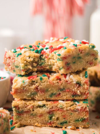 Close-up of stacked Christmas Blondies highlighting the chewy center and festive sprinkles.