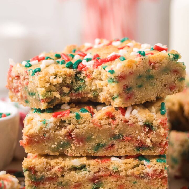 Close-up of stacked Christmas Blondies highlighting the chewy center and festive sprinkles.