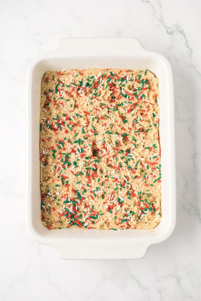 Blondie batter spread evenly in a baking dish before going into the oven.