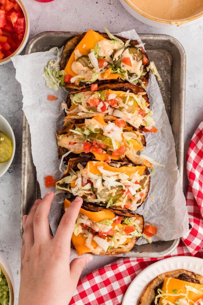 Smash burger tacos with melted cheese and fresh toppings being picked up