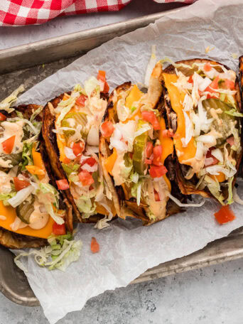 Smash burger tacos with melted cheese and fresh toppings on a serving tray