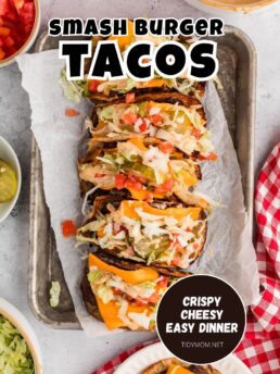 Smash burger tacos with melted cheese and fresh toppings on a tray