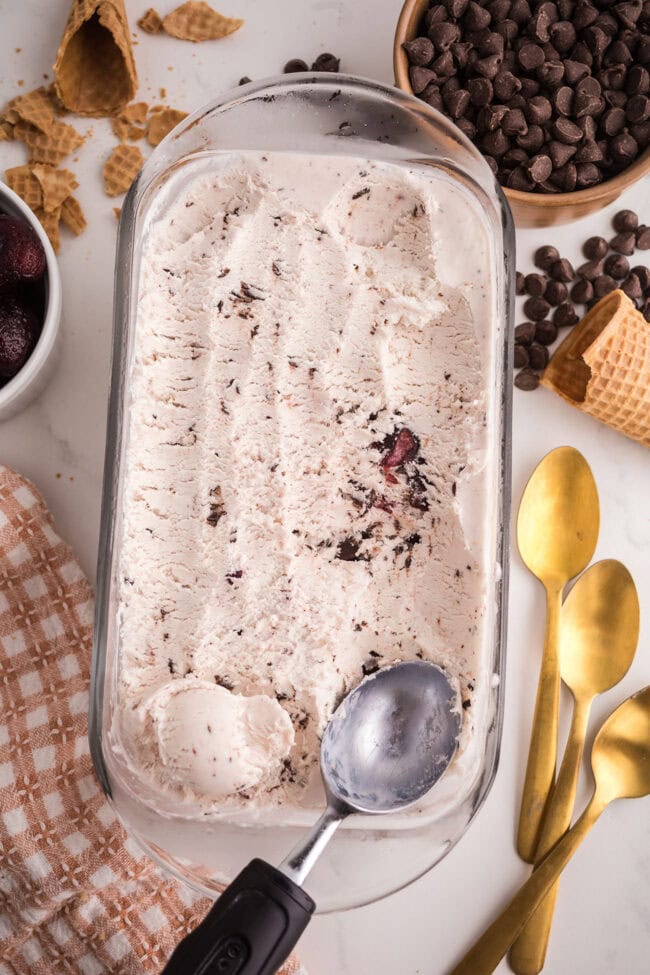 scooping homemade no-churn Cherry Garcia ice cream from loaf pan