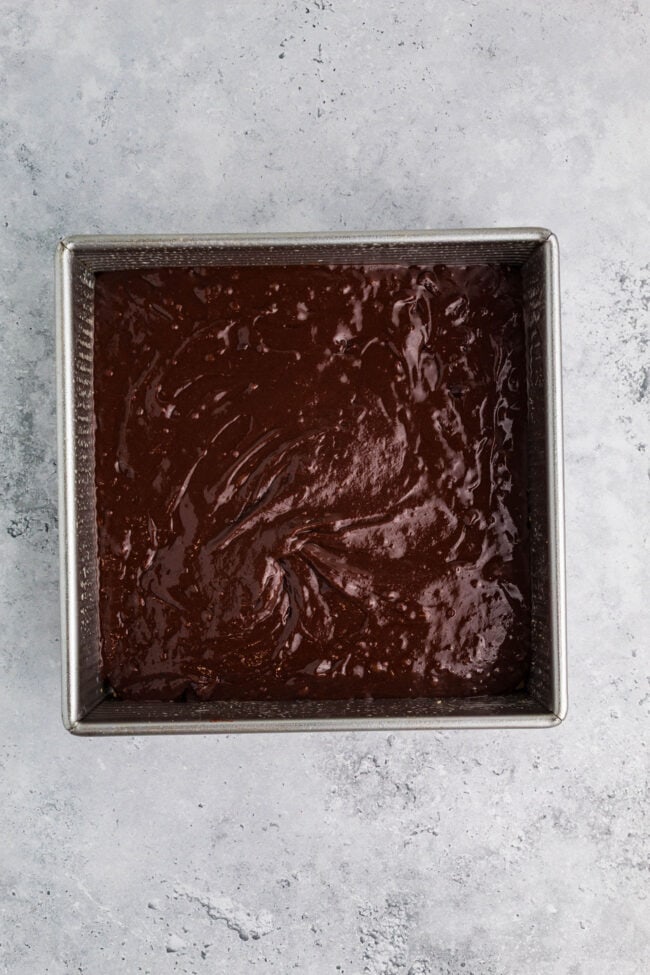 brownie batter in a square metal pan
