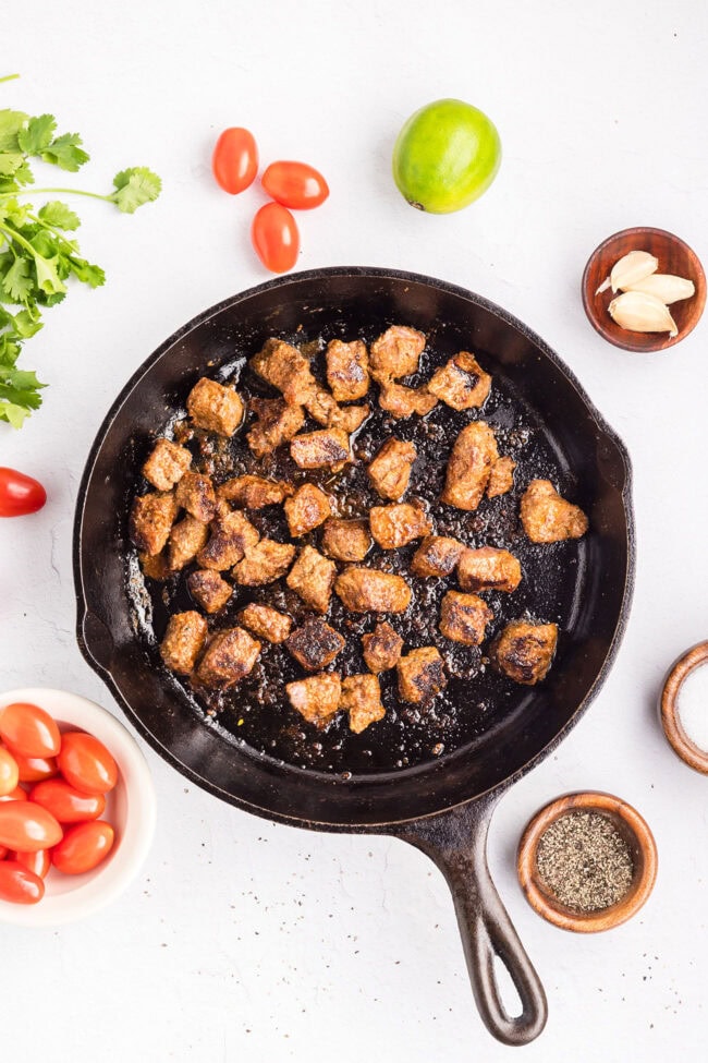 Cooking seasoned sirloin steak in a hot skillet until browned and caramelized