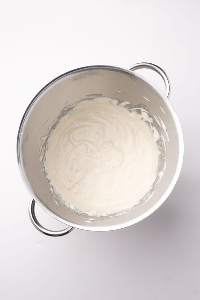 Creamy no-bake cheesecake filling whipped in a mixing bowl