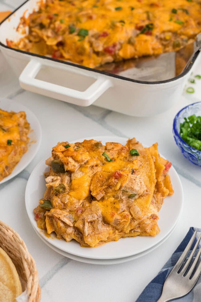 King Ranch chicken casserole served on a white plate with the baking dish in the background.